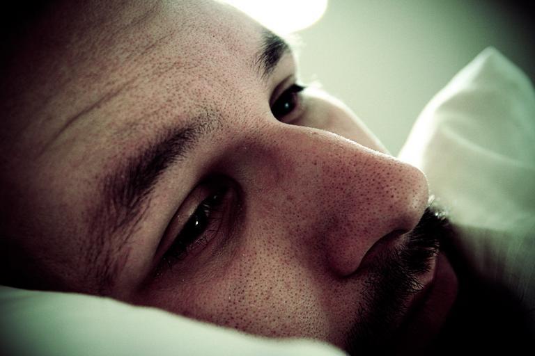 Muž leží v posteli, tvár, smutný, depresia