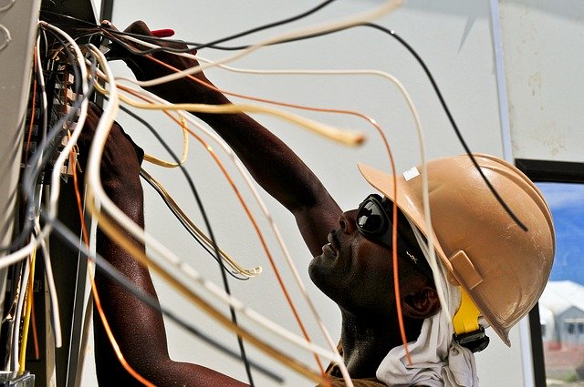 Elektrikár v prilbe montuje káble